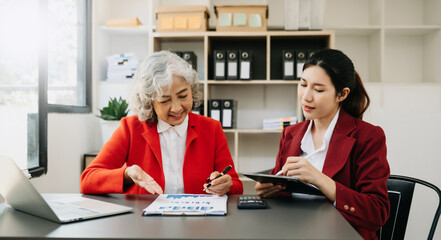 Kind leader executive manager share and discuss business solutions plan ideas on tablet with Asian female marketing manager in modern office..