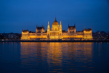 Fototapeta premium Budapest parliament illuminated at night and Danube river, Hungary