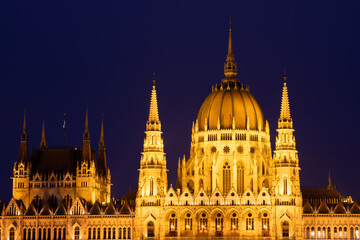 Obraz premium Budapest parliament illuminated at night and Danube river, Hungary
