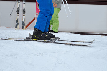 Black ski boots fastened into bindings close-up