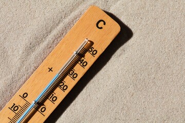 Wooden thermometer on the beach. 26 degrees Celsius. Summer concept. Copy space.