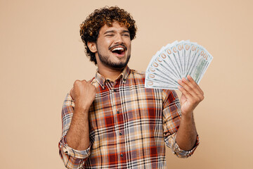 Young Indian man wear brown shirt casual clothes hold in hand fan of cash money in dollar banknotes...
