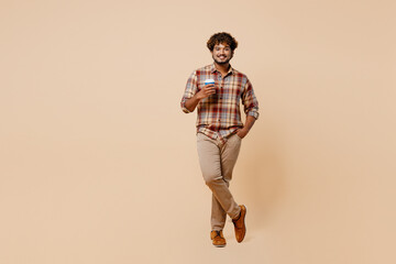 Full body young Indian man wear brown shirt casual clothes hold takeaway delivery craft paper brown...