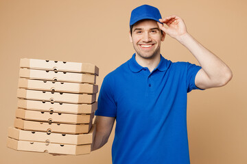 Smiling happy delivery guy employee man wear blue t-shirt uniform workwear work as dealer courier...