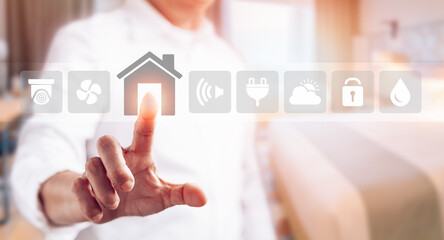 Man touching icons on virtual screen to connect objects in house interior