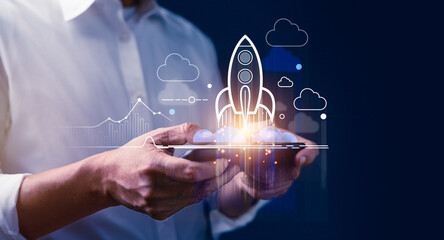 Businessman using smartphone with virtual rising rocket icons like growing business goals target