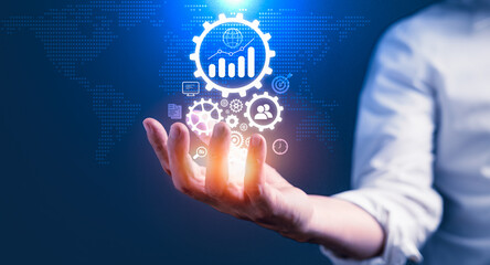 Businessman holding virtual business icons for planning to improve success goals target