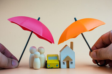 Agency protecting a family, home and car with two umbrellas, and double insurance. Management and insurance concept.