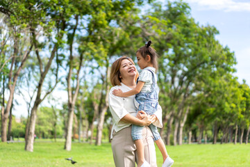 Naklejka na ściany i meble Portrait of happy love asian grandmother and asian little cute girl enjoy relax in summer park.Young girl with their laughing grandparents smiling together.Family and togetherness