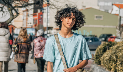 urban teenager  with afro hair walking down the street