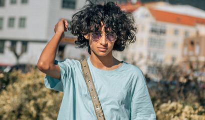 portrait of latin man afro hair  with vintage glasses outside