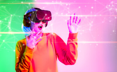 Obraz na płótnie Canvas Metaverse technology concept. Asian girl wearing vr goggles headset watching playing connecting to digital virtual world green pink color background.