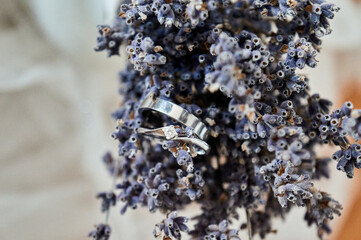Wedding rings on a lavender bouquet, close up