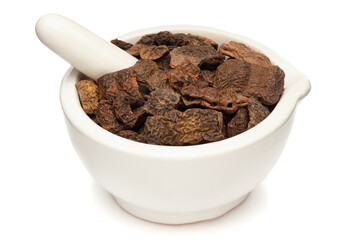 Closeup of Dry Shikakai (Acacia concinna) fruits, in white ceramic mortar and pestle, isolated on white background.