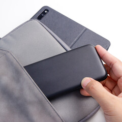 Close up man hand put power bank into the bag