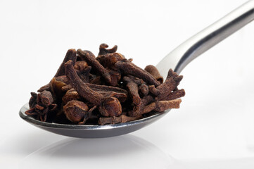 cloves in a spoon on white background