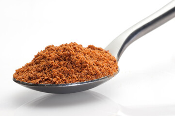 nutmeg in a spoon on white background