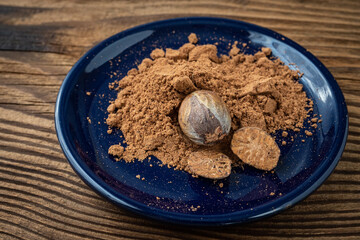 Nutmeg whole and grated in ceramic bowl