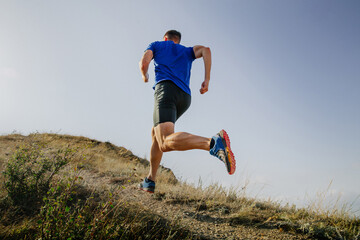 back athlete runner run mountain trail on background sky