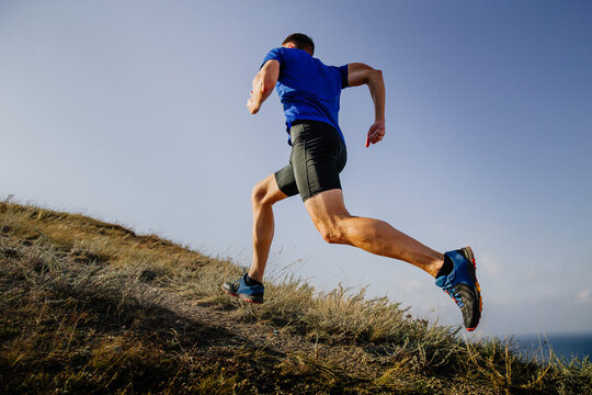 athlete runner run mountain trail on sky background