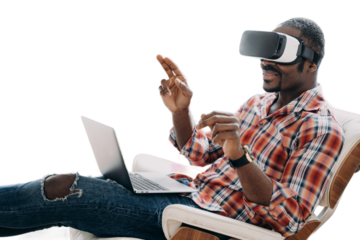 African american man in virtual reality glasses works or play video game on laptop, sitting in chair