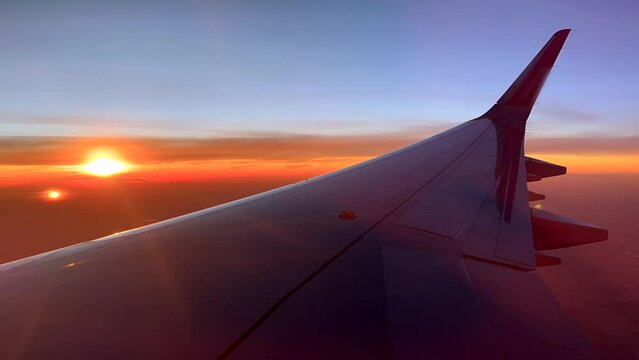 Timelapse plane wing flying with beautiful sunset in sky over Africa