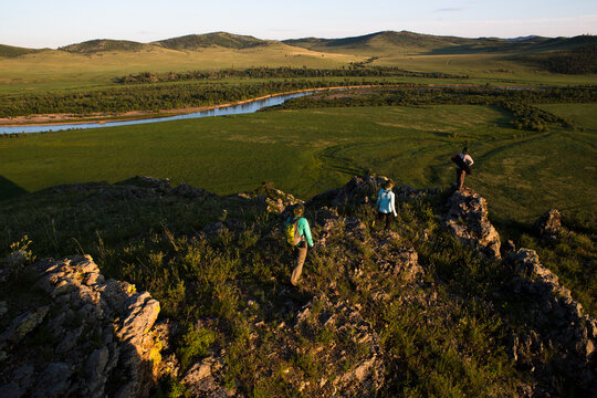 Three women hike to a vantage point over looking the Onon river in northern Mongolia.
