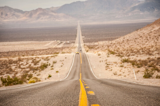 The road that leads to Death Valley from Beatty is lost on the horizon in the desert plain. Beatty, Nevada.