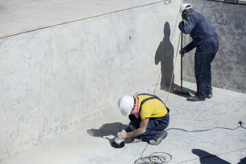 Concrete ceiling surface of the pool grinding by angle grinder