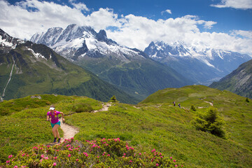 Female runner Chrissy Roe on a trail in the valley of Chamonix with the Mont Blanc range in the background.