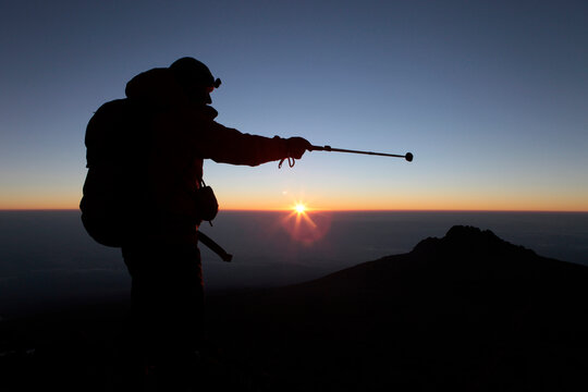A hiker enjoying sunrise near the summit of Kilimanjaro.