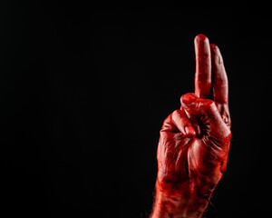 Close-up of a male bloody palm showing two fingers on a black background. 