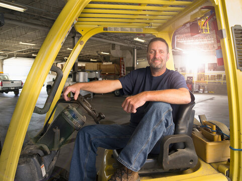 A well-built man sits on the driver&acirc;&euro;&trade;s sit of a utility vehicle.