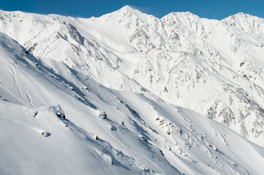 Distant View Of Sandra Hillen Snowboarding Through Powder In The Japanese Alps