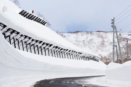 Snowboarder Jumping Off An Avalanche Wall In Japan
