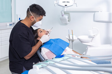 Dentist examining teeth of teenager