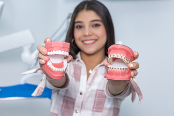 Smiling ethnic female teenager showing dentures in clinic