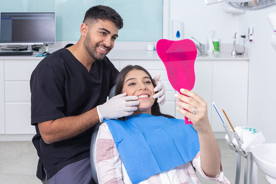 Dentist and patient admiring teeth