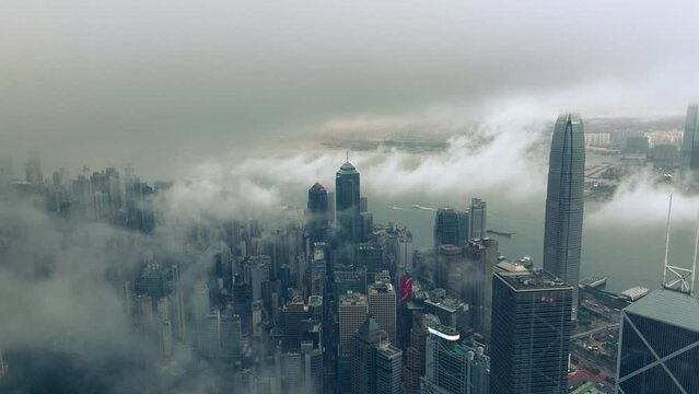 Low Clouds Between Buildings, Bank of China, The Center, International Finance Center, Hong Kong. Gloomy Cinematic Drone Wide Establishing Shot