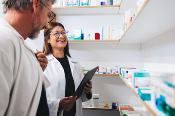 Male and female pharmacists working together in a chemist