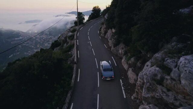 Old vintage car driving in the French mountains outside Monaco.