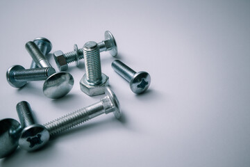 Set of bolts on a white background. Construction abstraction. Industrial background. Screws and bolts macro photo, screw background, steel screw, bolt macro.