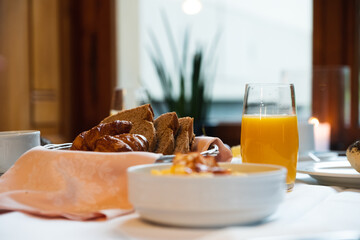 Breakfast at the table served with orange juice, bread and scrambled eggs
