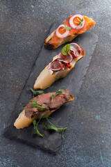 Three types of bruschetta. with meat, dried tomatoes and salmon.