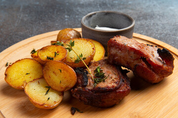 Fried meat and new potatoes on the board.