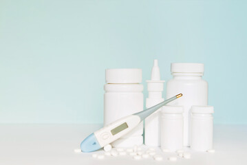 Set of different white  medicine bottles, pill bottles without label design, pills, copy space on blue background