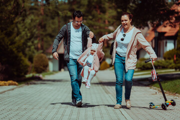 Family fun in the park. Happy family spending time in park and playing with their daughter