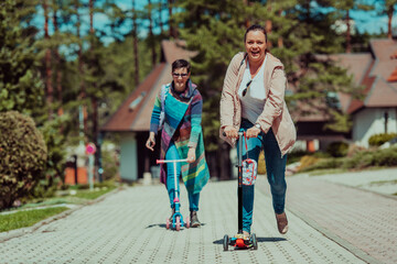 Two women having fun in the park while riding a scooter