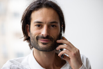 portrait d'un jeune homme d'affaires ou employé de bureau souriant qui utilise un smartphone.