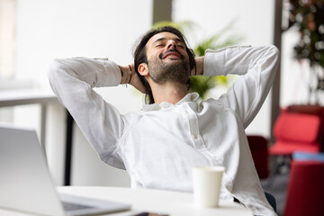 homme employé de bureau ou homme d'affaires souriant qui se relaxe au bureau devant son ordinateur...